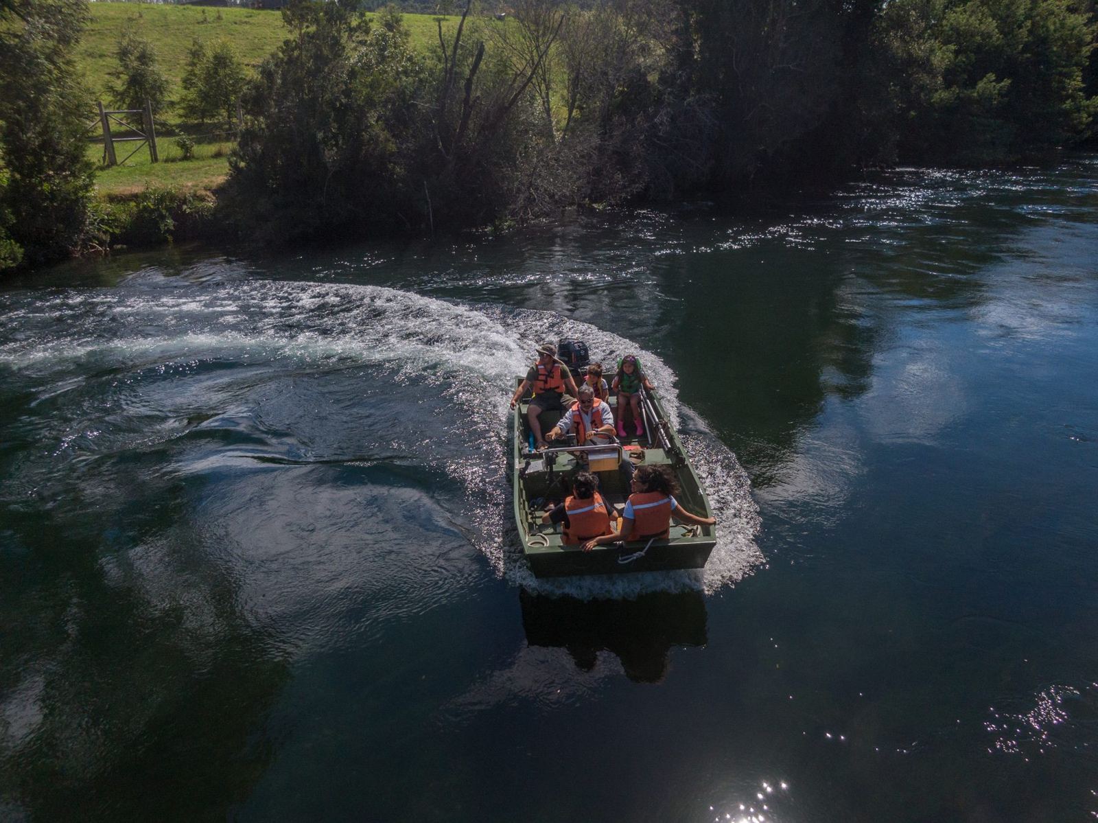 Bote Río Maullín navegando con una familia a bordo, visto desde el aire, con chalecos salvavidas